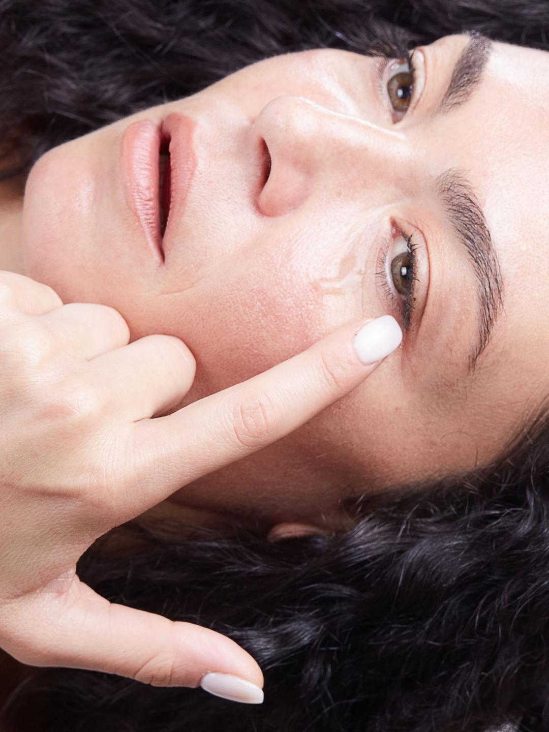 Primo piano di modella che applica il Gel Contorno Occhi ANIMA